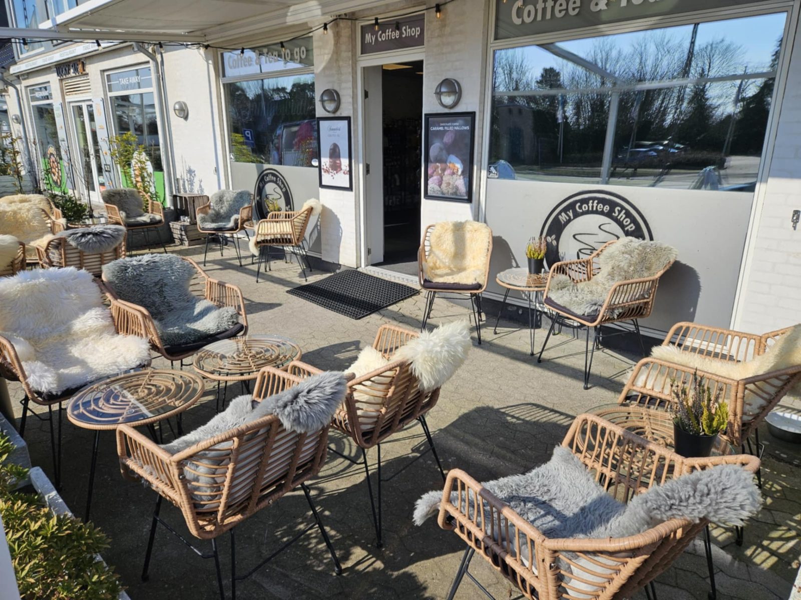 My Coffee Shop i Greve Strand — facade med udendørs loungeområde og lammeskind på stolene